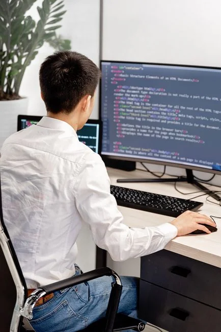 A stylish workspace featuring a laptop and monitors displaying design software.