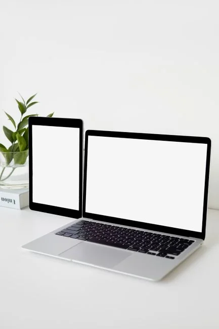 Close-up of hands typing on a laptop next to a cup of coffee on a wooden desk.